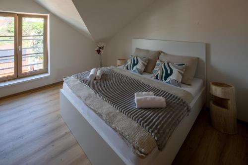 a bedroom with a large bed with two pillows at Apartmány LISON in Valtice