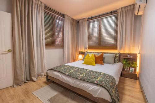 a bedroom with a bed in a room with windows at 행궁주택 in Samgong