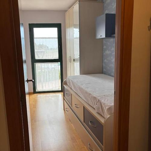 a bedroom with a bed and a door with a window at Kalma Samaria in Pals