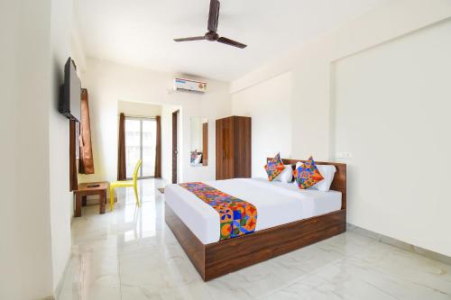 a bedroom with a bed and a tv in it at FabHotel Destiny Living in Pune