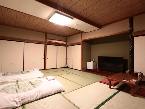 a room with two beds and a flat screen tv at Hotel B FUJI-YAMANAKAKO in Yamanakako