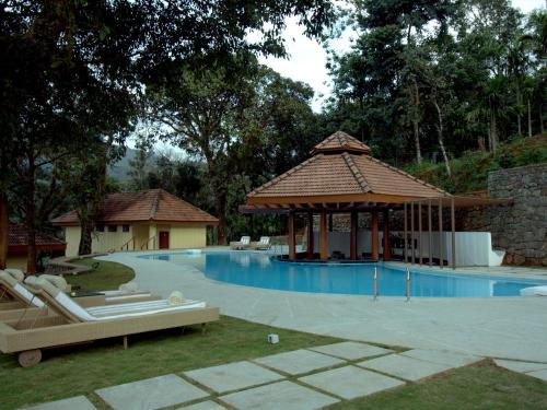 a swimming pool with a gazebo and a pavilion at The Tamara Coorg in Kakkabe