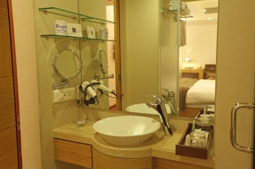 a bathroom with a sink and a mirror at Comfort Inn Legacy in Rajkot