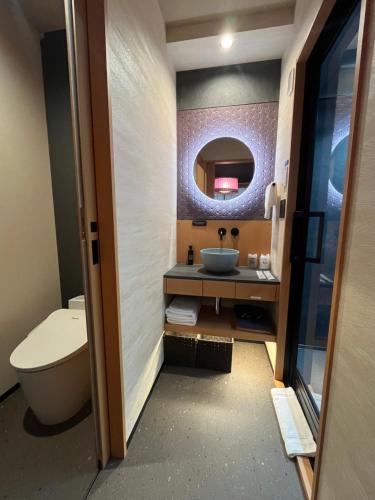a bathroom with a sink and a toilet and a mirror at Hotel Matsunoi Shurin in Tokyo