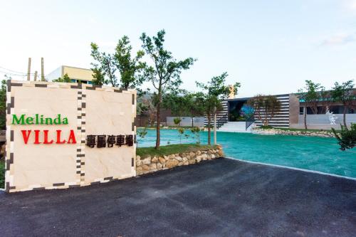 een bord waarop staat Melilla Villa naast een zwembad bij Melinda Resort in Hengchun