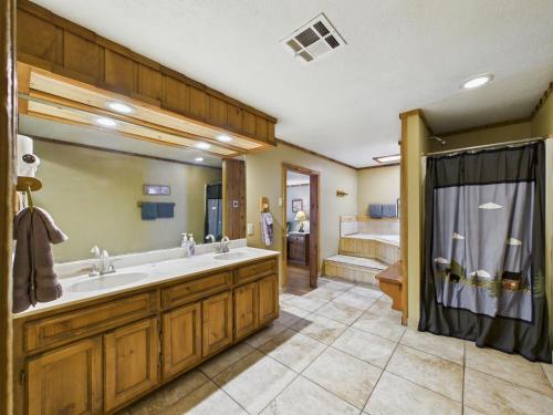 a bathroom with a large sink and a shower at Whispering Pine Cabins in Ruidoso
