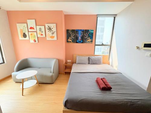 a small bedroom with a bed and a chair at Dear You, Apartment! Saigon - Rivergate Building in Ho Chi Minh City