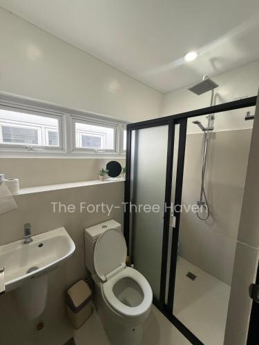 a bathroom with a shower and a toilet and a sink at The Forty-Three Haven in Calo