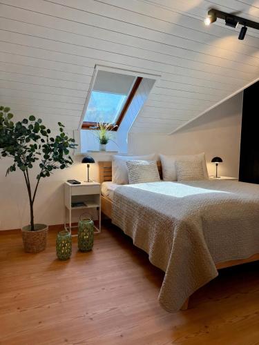 a bedroom with a large bed and a window at Landhaus Wulfenia - APARTMENT KLAGENFURT - Private Sauna, Smart-TV, Air Conditioning, Free Parking in Klagenfurt