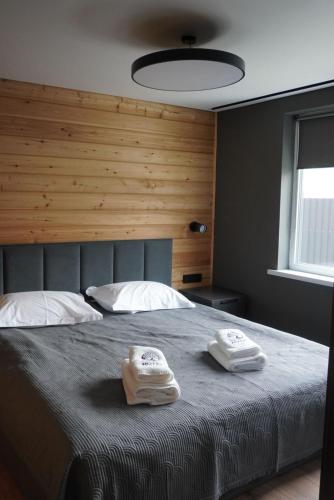 a bedroom with a bed with two towels on it at Turanga hotel in Saty