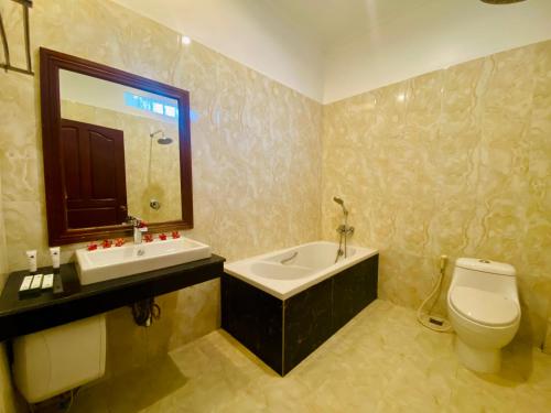 a bathroom with a sink and a toilet and a tub at STC Hotel School in Phumĭ Réach Born (1)