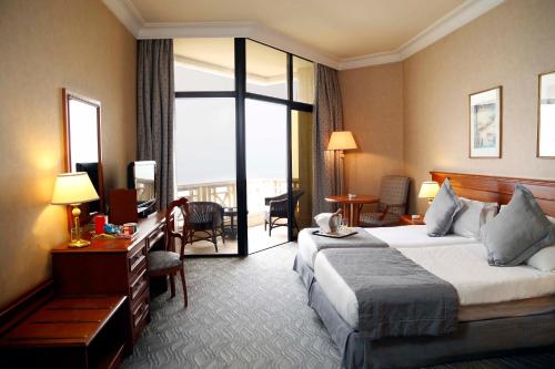 a hotel room with a bed and a balcony at Bayview Hotel Beirut in Beirut