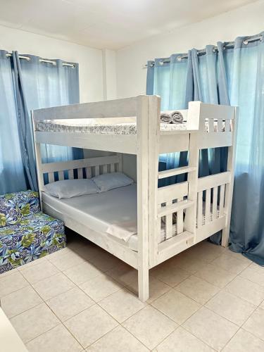 two bunk beds in a room with blue curtains at Oslob Cozy Home in Oslob
