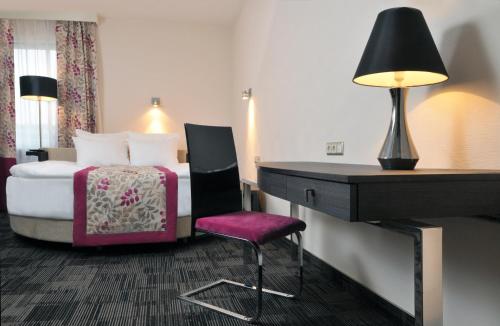 a hotel room with a bed and a desk with a desk at Hotel 3 Trio in Białystok