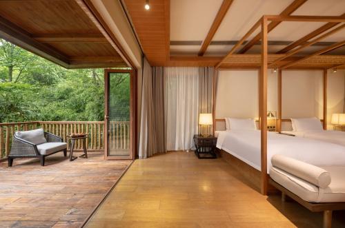 a bedroom with a bed and a balcony at Evergreen Forest Retreat Zhangjiajie, Near National Forest Park Avator Park, Luxury Nature Escape, Free Airport&Train Shuttle Service & Travel itinerary, English Speaking Butler in Zhangjiajie