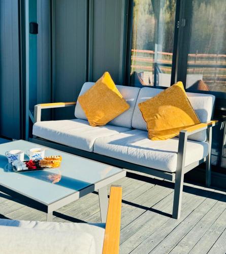ein Wohnzimmer mit Sofa und Couchtisch in der Unterkunft Peak View Tiny House - Piatra Craiului Nest in Zărneşti