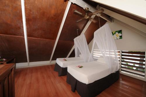 a room with two beds and a ceiling fan at Erakor Island Resort & Spa in Port Vila