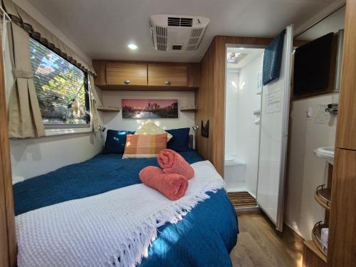 a small bedroom with two towels on a bed at A Tiny Home Experience in a great spot in Melbourne