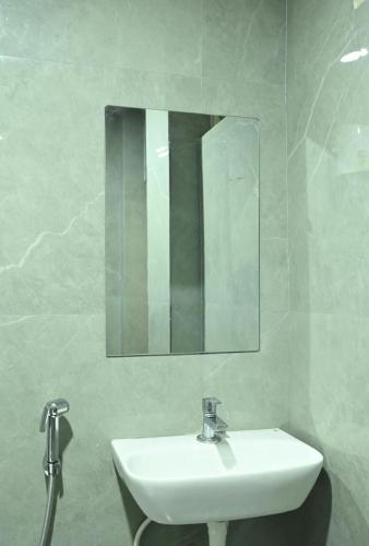 a bathroom with a white sink and a mirror at Hotel Sree Kanya Inn in Visakhapatnam
