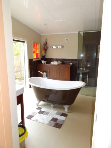 a large bathroom with a tub and a shower at Thyme On The Terrace in Te Anau