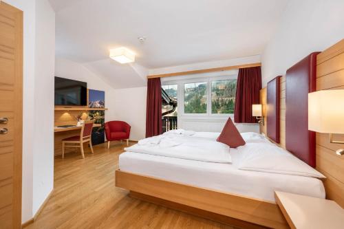 ein Hotelzimmer mit Bett und Schreibtisch in der Unterkunft Hotel Sonnschupfer in Schladming