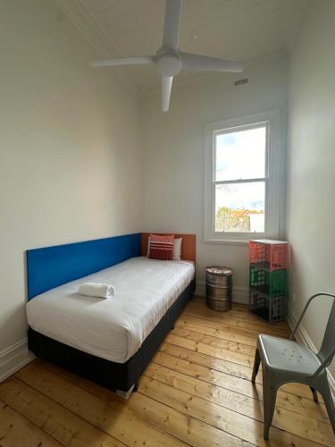 a bedroom with a bed and a chair and a window at ARK Apartments in Echuca