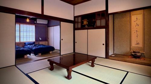 a room with a table and a bed and a mirror at Nuu Takedamise, the Villa in Kami-yuge