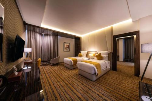 a hotel room with two beds and a television at فندق الراية الفندقية in Jazan