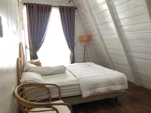 a bedroom with a bed and a window at The Kaluna Resort in Lamno