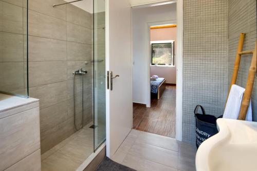 a bathroom with a shower with a glass door at Elaion Serenity in Lákka
