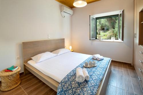 a bedroom with a bed with towels and a window at Elaion Serenity in Lákka