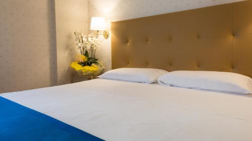 a bedroom with a large white bed with two pillows at Hotel Lombardia in Milan