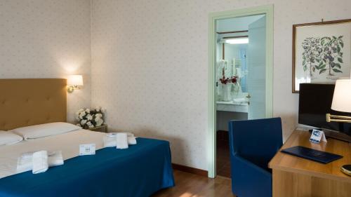 a bedroom with a bed and a desk and a chair at Hotel Lombardia in Milan