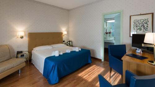 a bedroom with a bed and a couch and a desk at Hotel Lombardia in Milan
