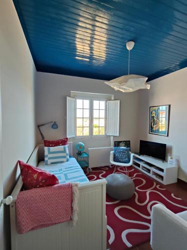 a bedroom with a blue ceiling and a red carpet at Flat 23 in Bombarral