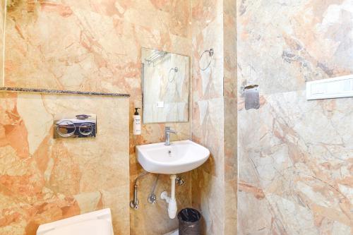 a bathroom with a sink and a toilet and a mirror at FabHotel Madhuban in Jaipur