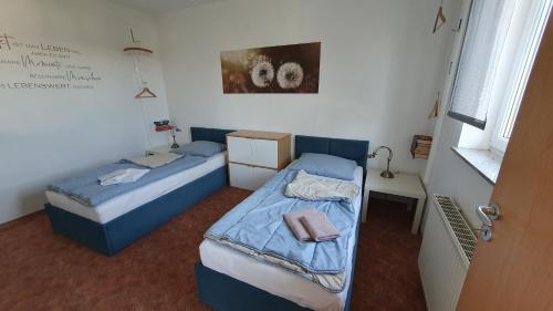 two beds in a small room with a window at Apartment Christa in Schwendi