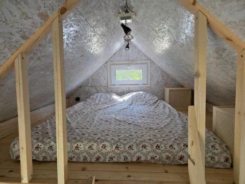 a bedroom with a bed in a attic at Domek POD LASEM in Białowieża
