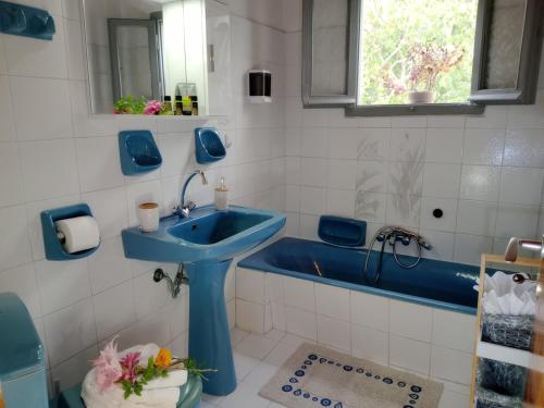 a bathroom with a blue sink and a tub at Villa Makris in Zenempisátika