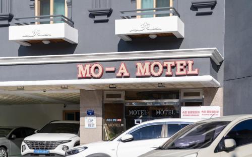 a sign for a motel with cars parked in front at Mo-A Motel in Sokcho