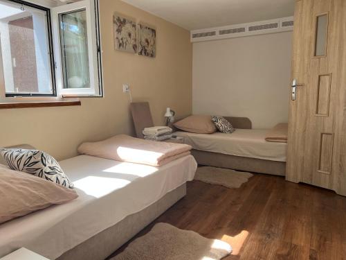 a room with two beds and a window at Apartament tatarski PARKING! in Przemyśl