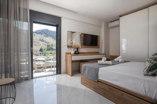 a bedroom with a bed and a desk and a window at Calma Luxury Villas in Kolymbia