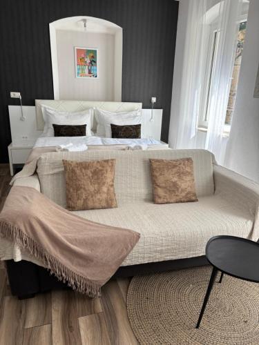 a bedroom with a bed and a couch with pillows at Studio Apartman Fictilis in Split
