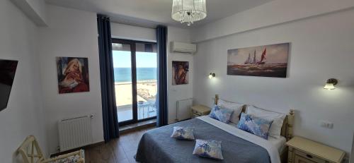 a bedroom with a bed with a view of the ocean at Bluemarina Apartamente in Mamaia