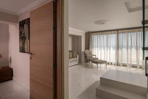 a living room with a sliding door and a dining room at La Mer Escape in Nikiti
