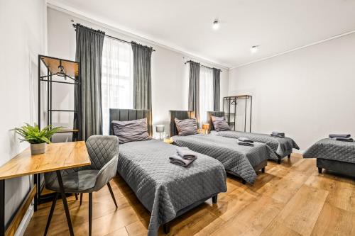 a living room with three beds and a table at Platinum Prestige Residence in Rybnik