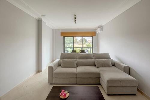 a living room with a couch and a table at 2-Bed Vialonga Vista Apartment in Lisbon