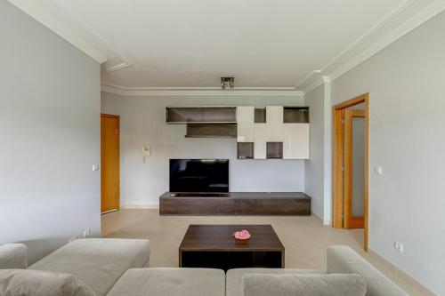 a living room with two couches and a tv at 2-Bed Vialonga Vista Apartment in Lisbon