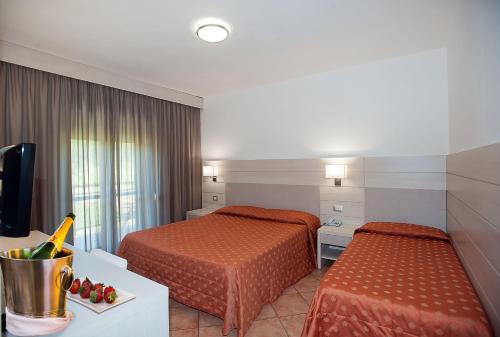 a hotel room with two beds and a television at Magnola Palace Hotel in Ovindoli