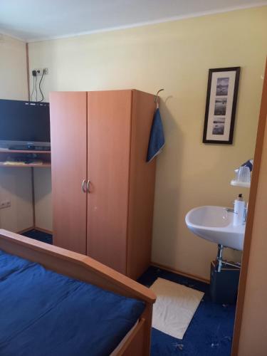 a room with a bed and a cabinet and a sink at Privatzimmer Daniela und Hubert Gosch in Mixnitz